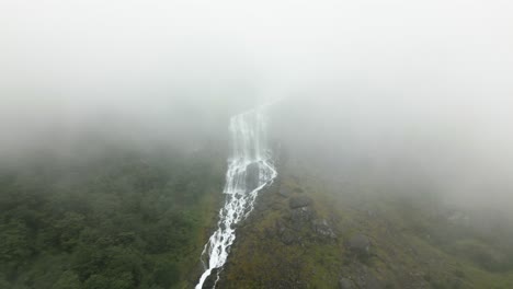 una gran cascada en una montaña entre mucha niebla, noruega, naturaleza, avión no tripulado