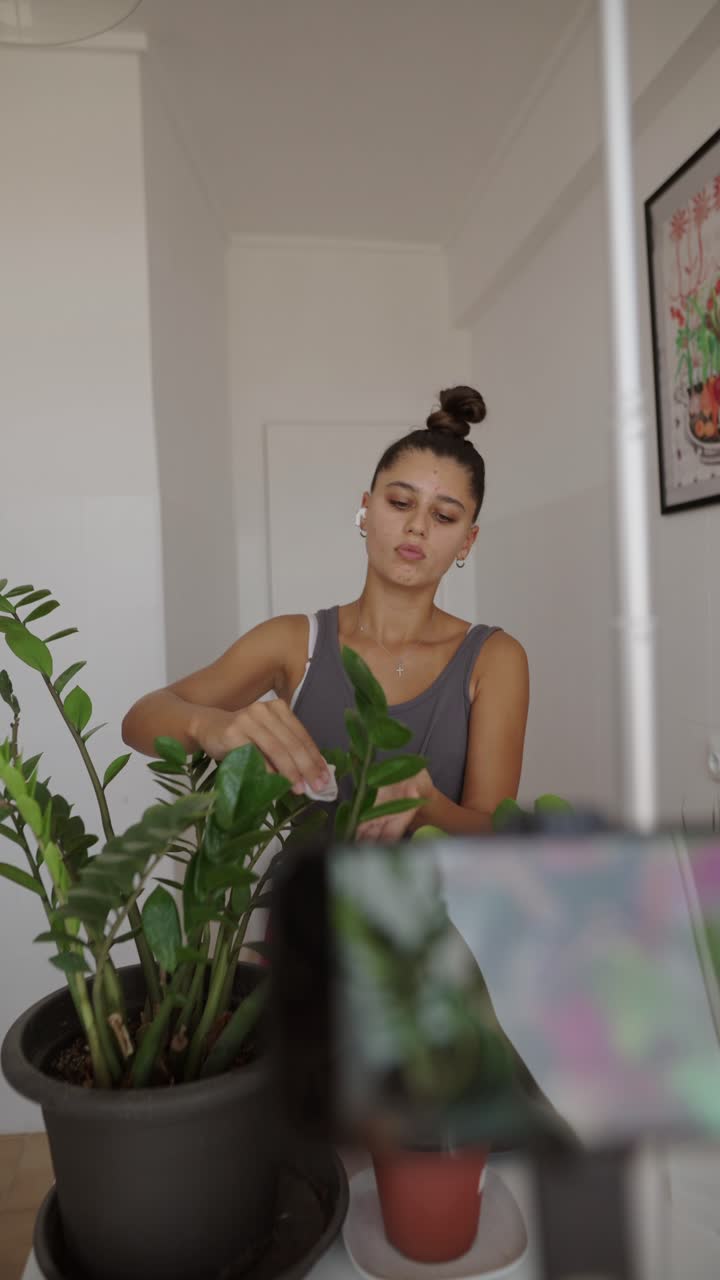 Woman taking care of her ZZ plant indoors