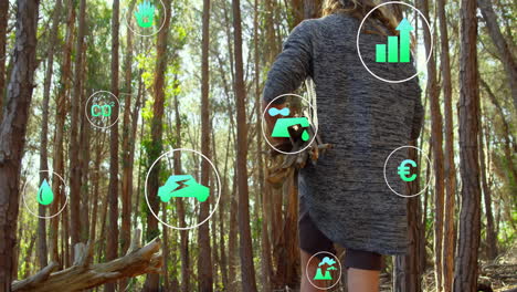 Man walking through pine forest, carrying sticks, displaying floating green technology icons