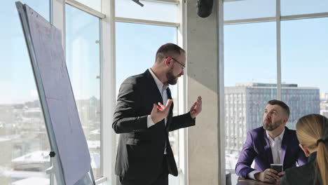 businessman in suit talking to business people colleagues or partners sitting at conference table. leader discussing work at morning team meeting.