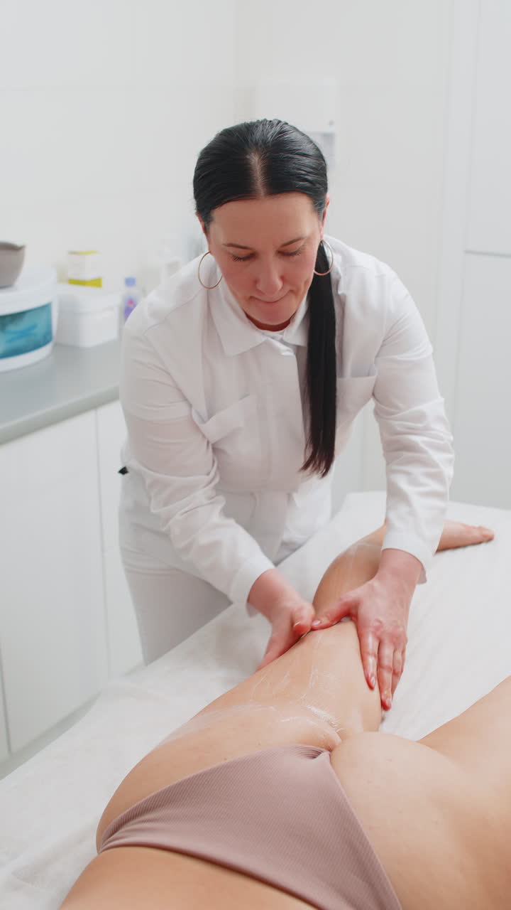 Beautician therapist doctor making woman relaxing spa anticellulite legs treatment hands massage