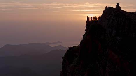 silhouette of hikers at sunrise crowd viewpoint ninho da manta, near pico do arieiro at popular madeira trail, drone view