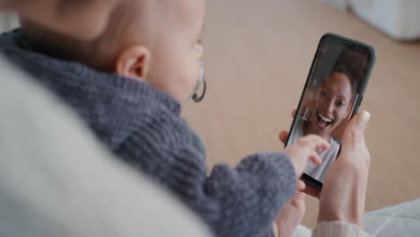 mother and baby using smartphone having video chat with best friend waving at toddler happy mom enjoying sharing motherhood lifestyle on mobile phone screen 4k