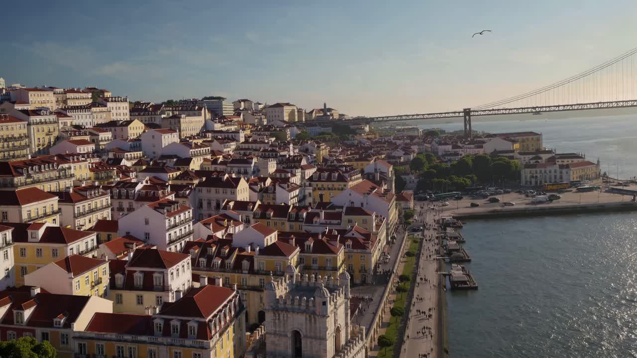 Video aereo riprende un panoramico paesaggio urbano costiero con tetti colorati e un ponte.