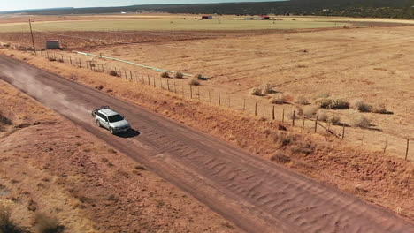 Camioneta-Plateada-Con-Portabicicletas-En-La-Carretera-Del-Desierto-Rojo,-Antena