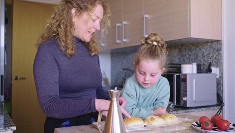 mother and daughter making sandwiches in the kitchen