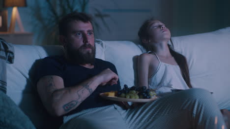 father and daughter watching tv at night