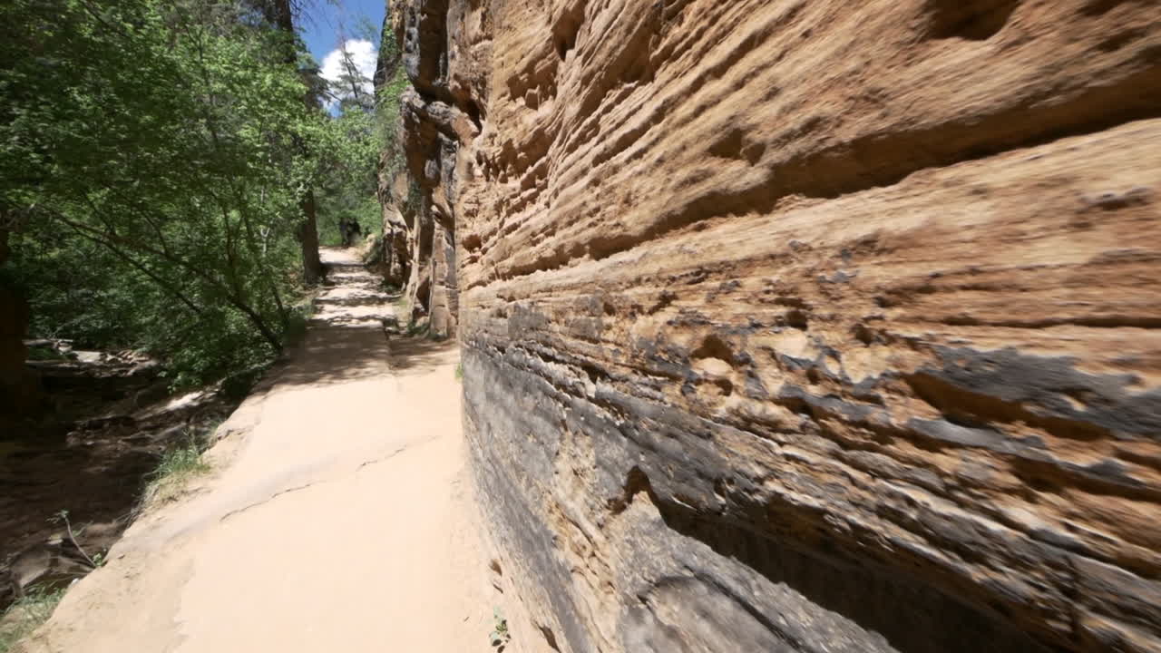 Walking along a sheer canyon wall trail Zion National Park, Utah, USA