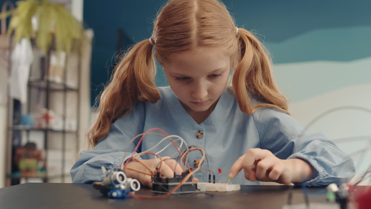 Young girl building an electronic circuit for a robotics project