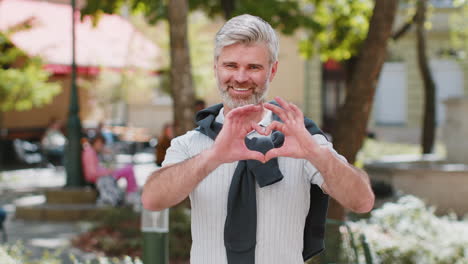 Reifer-Mann-Macht-Symbol-Der-Liebe-Durch-Herz-Zeichen-In-Die-Kamera-Drücken-Romantische-Positive-Gefühle