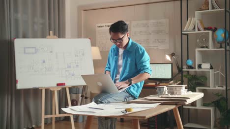 asian man engineer sitting on the table and using a laptop to work at the office