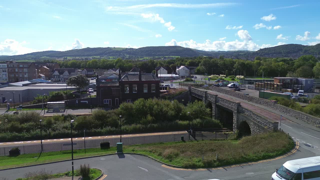Penrhos and Abergele coastal railway station aerial view across promenade and mountains skyline