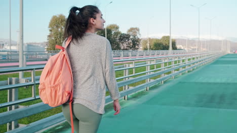 mujer caminando por un puente de la ciudad