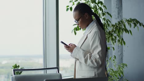mujer de negocios enviando mensajes de texto en la oficina