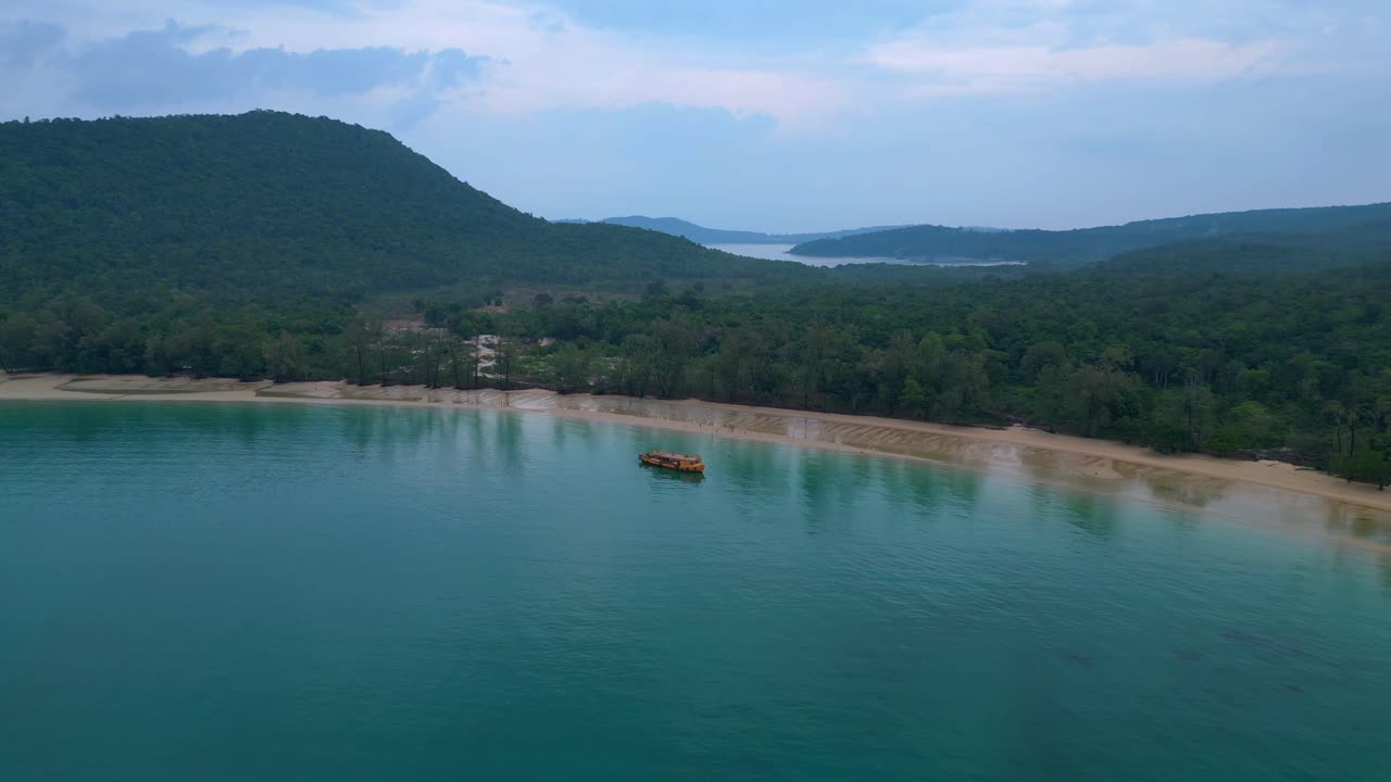 Tourists enjoying Koh Rong Sanloem beach and sea, swimming near a tour boat, aerial view from above. Breathtaking aerial view flight pull in drone