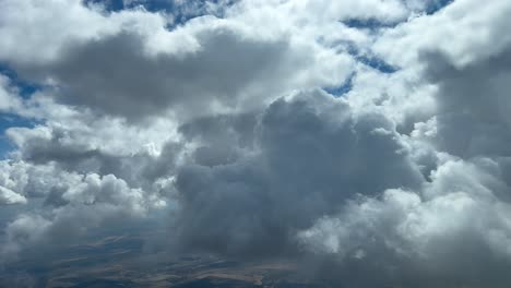 Awesome-view-from-a-jet-cockpit,-pilot-point-of-view,-flying-through-a-turbulent-sky-full-of-clouds-with-a-deep-blue-color-sky