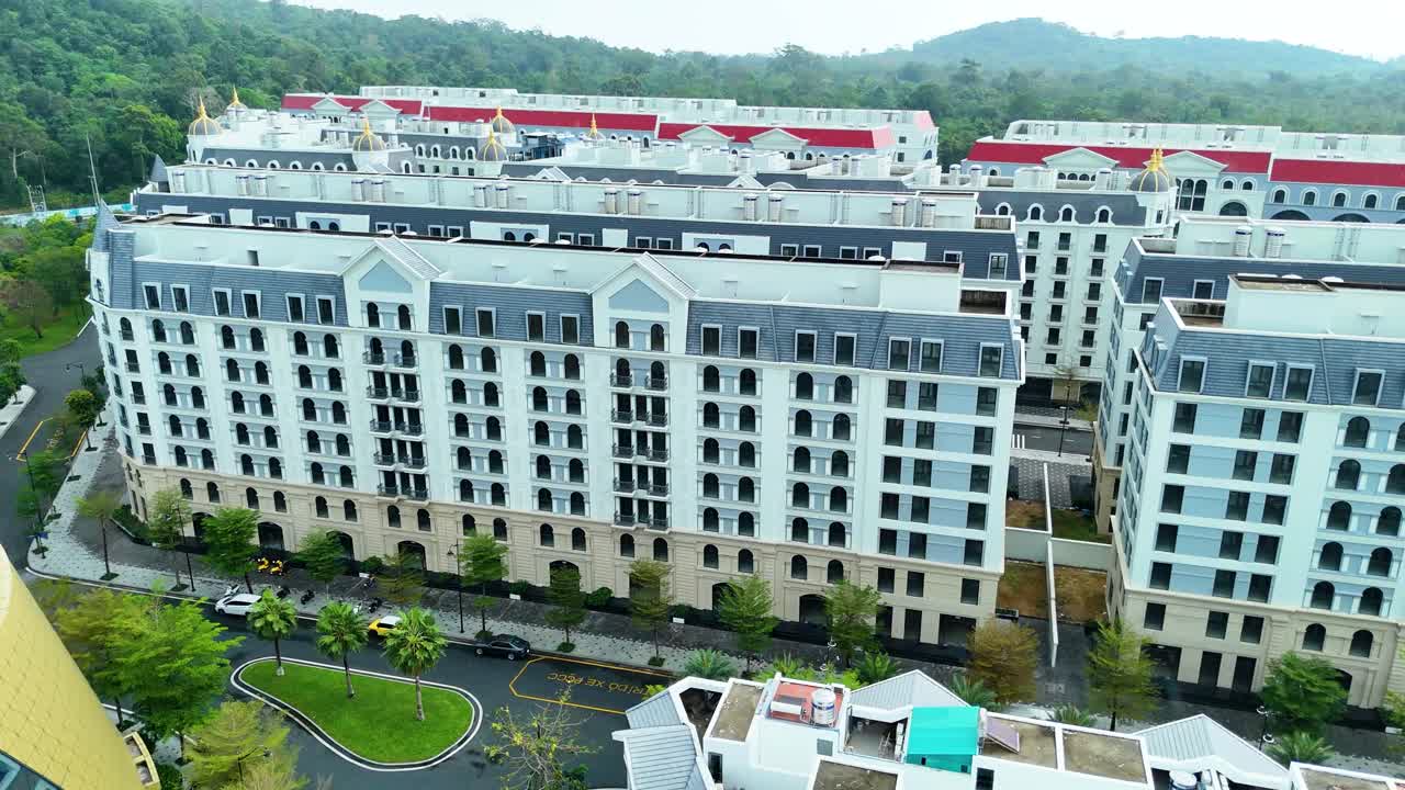 Aerial view of the Grand World development on Phu Quoc Island, Vietnam, showcasing a replica of Venice-style architecture in a quiet, empty residential area surrounded by lush greenery.
