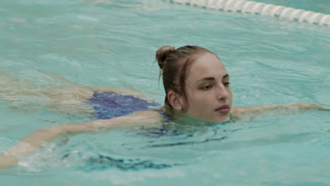beautiful woman practicing swimming in pool