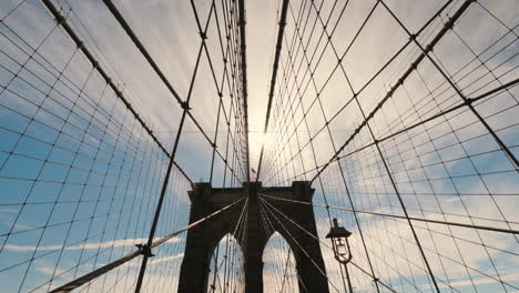 the silhouette of the pylons of the brooklyn bridge a lot of ropes hold the canvas of the bridge