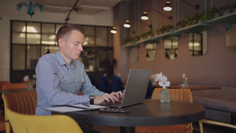 hermoso desarrollador masculino o estudiante trabajando estudiando con computadora portátil en una cafetería. trabajo remoto independiente educación en línea autónomo