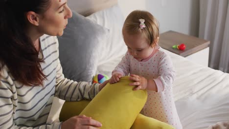 Kaukasische-Mutter-Und-Baby-Spielen-Zu-Hause-Mit-Spielzeug-Auf-Dem-Bett