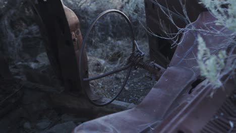 Rusty-steering-wheel-in-an-abandoned-station-wagon,-shot-from-front