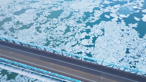 close-up aerial of ambassador bridge deck over ice-covered detroit river