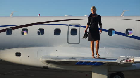 slomo: a playful flight attendant walks on the wing of an aircraft