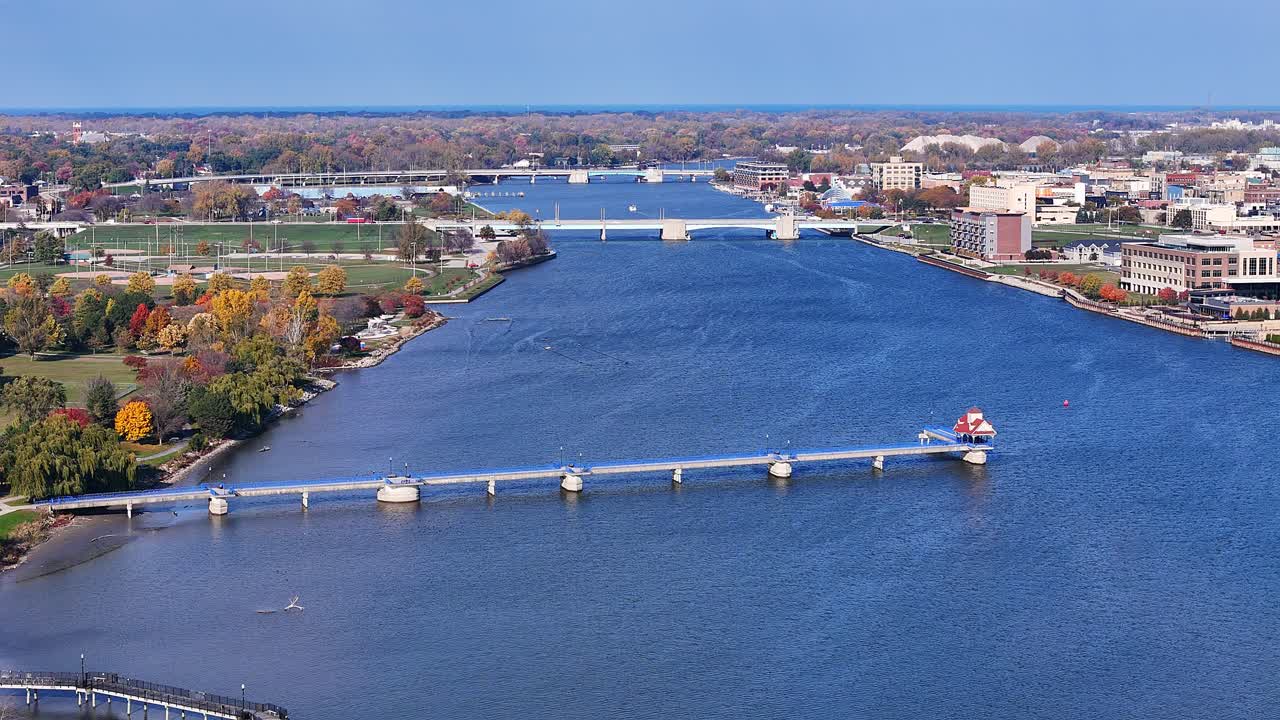 Il pontile della passeggiata sul fiume a Bay City, Michigan, USA, un lungomare con un molo, più ponti ed edifici costieri, in vista aerea.