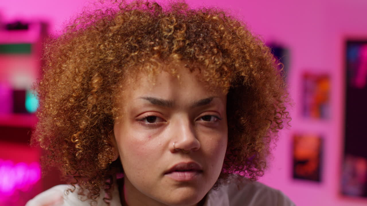 mujer con cabello rizado en una habitación rosa