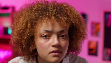 woman with curly hair in a pink room