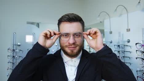 man trying glasses at store. portrait of man doing visual examination at optical center