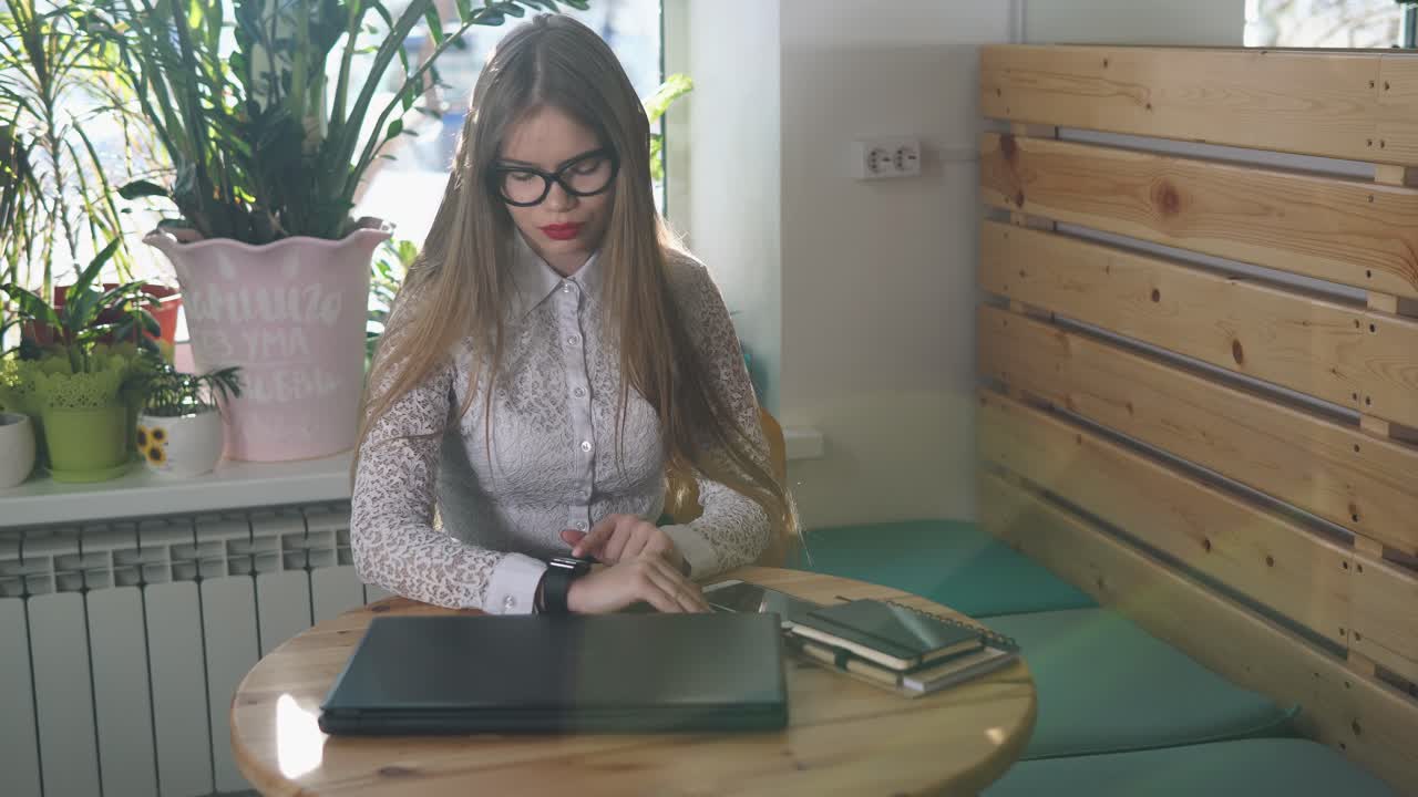 Una mujer joven trabajando en un café.