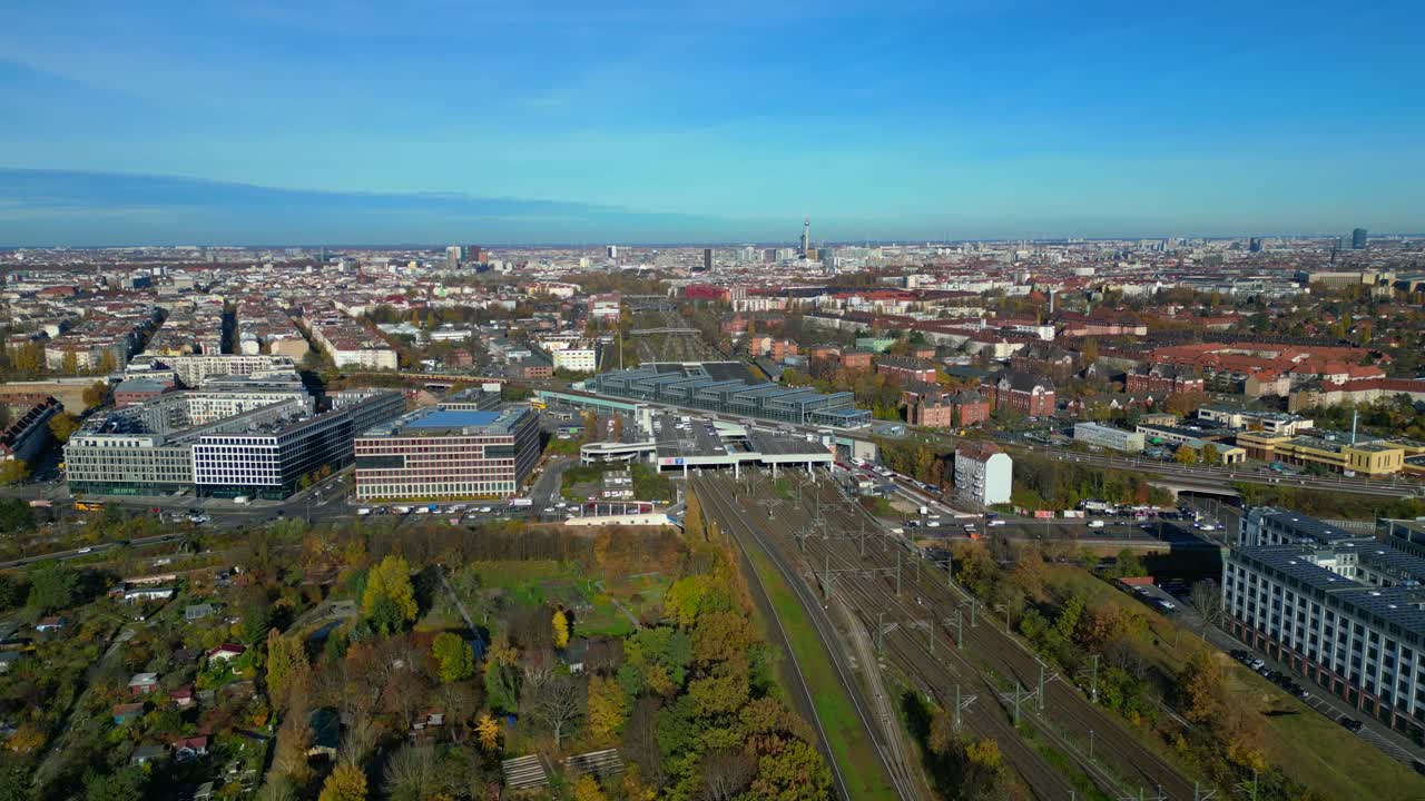 Berlin cityscape with a modern train station South Cross and extensive railway lines under a clear sky. Majestic aerial view flight descending drone