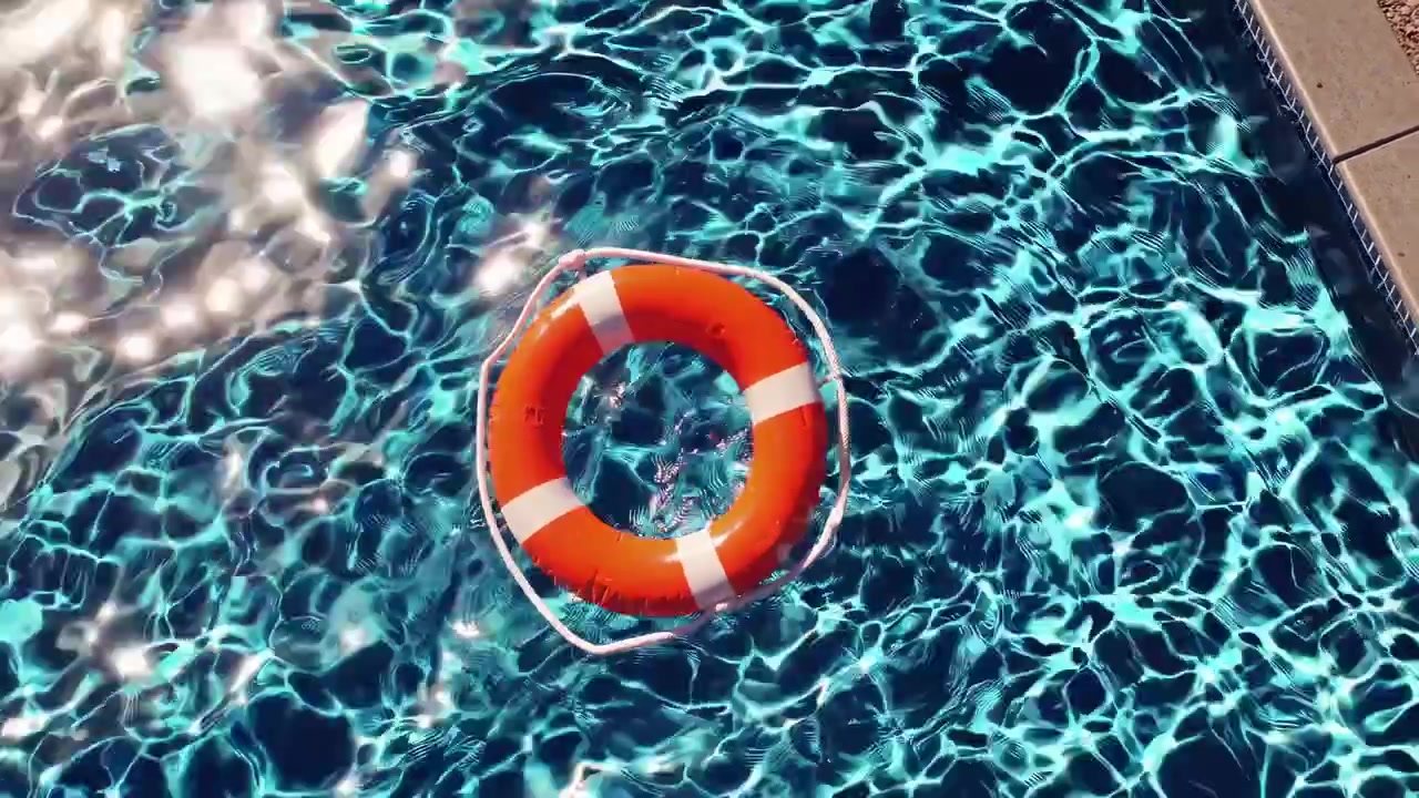 Orange Lifebuoy Floating in a Blue Swimming Pool