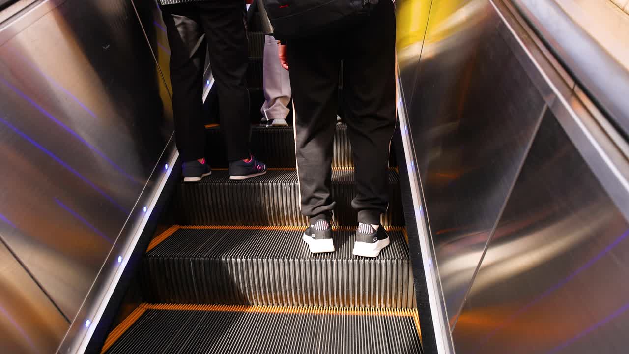 바쁜 지역 에서 에스컬레이터 를 타고 있는 사람 들