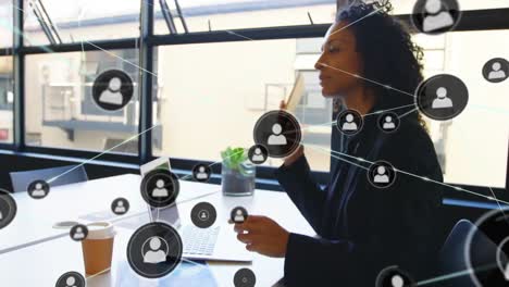 Animation-Eines-Netzwerks-Von-Profilen-über-Eine-Biraziale-Geschäftsfrau,-Die-Im-Büro-Auf-Dem-Smartphone-Spricht