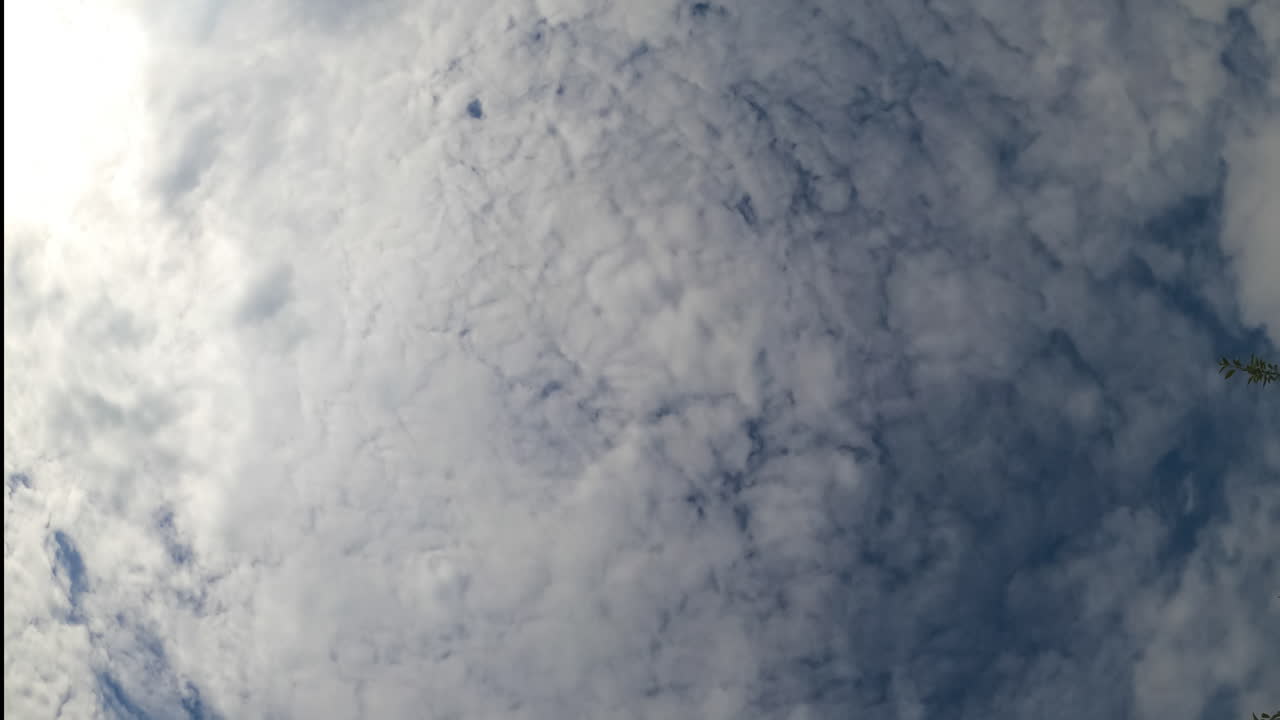 Rainy cloudscape formation in the atmosphere. Cirrus clouds covering the blue sky. Low angle view.