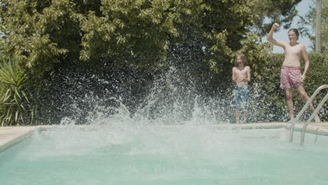 padres felices corriendo a la piscina en la fiesta familiar mientras su hijo los mira