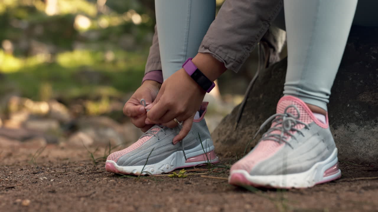 Escursioni, foresta e mani che allacciano le scarpe all'aperto