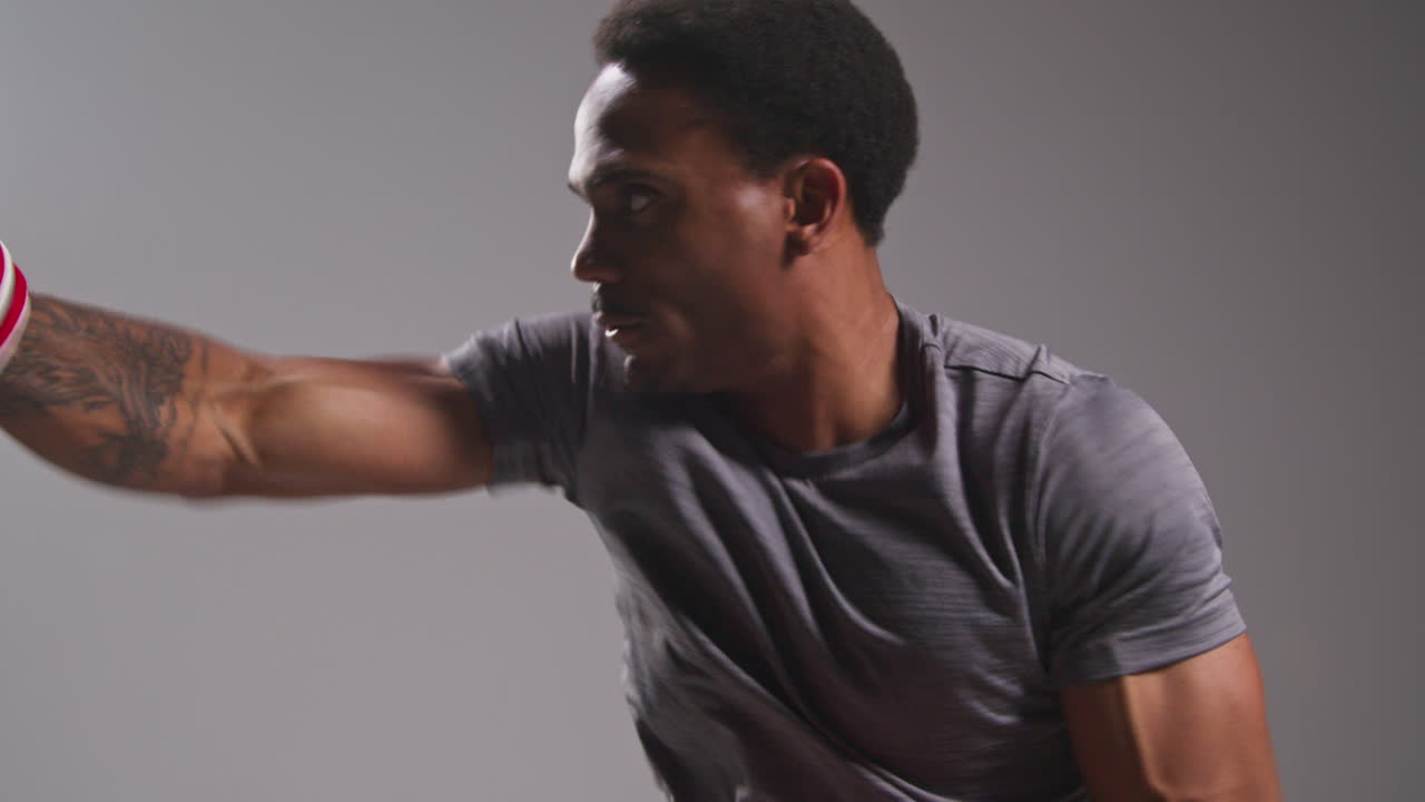 남자 권투 선수가 스파링을 하고 트레이너와 함께 치 손바닥이나 장갑을 착용하여 싸움을 위해 연습하는 스튜디오