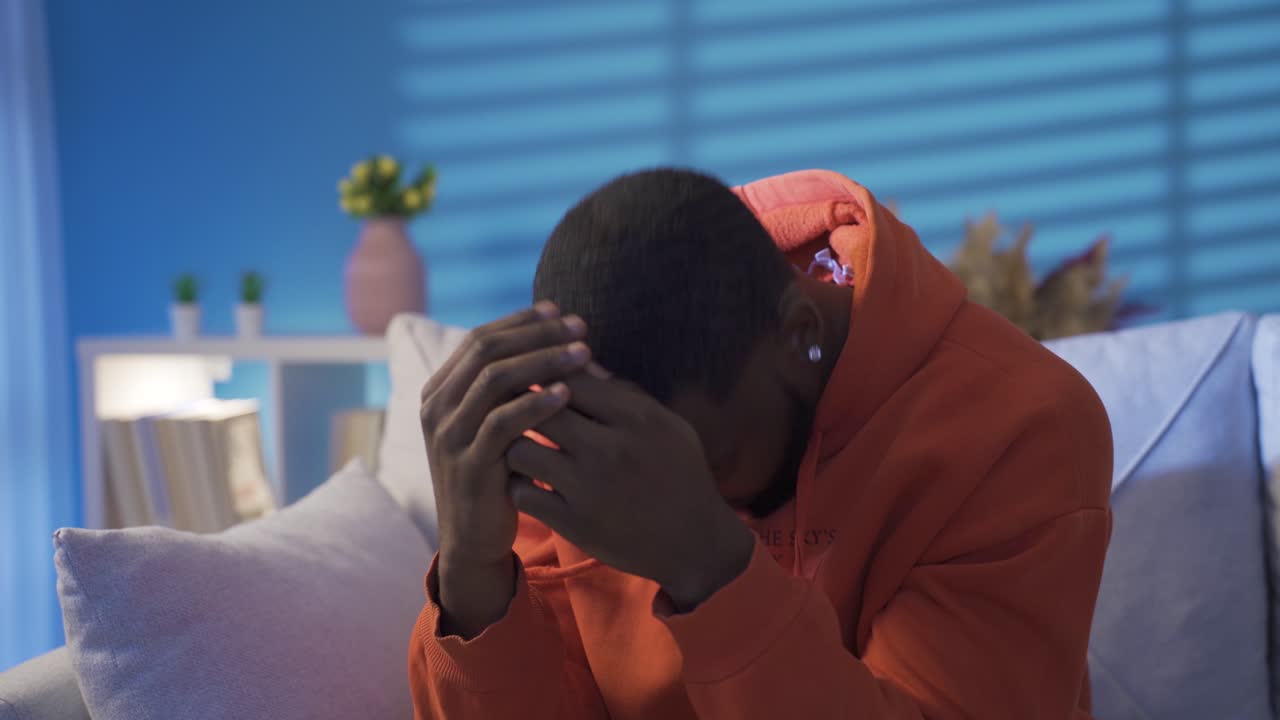 Thoughtful and stressed black man alone at home.