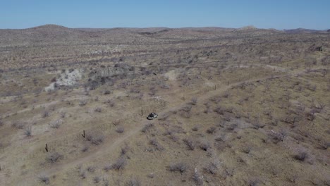 Safari-Jeep,-Der-Entlang-Der-Zaunlinie-Fährt,-Luftaufnahme,-Etosha,-Namibia