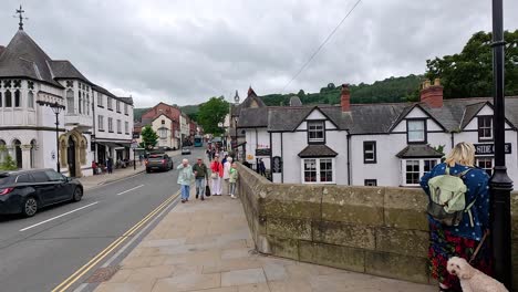 people walking on a bridge in a quaint town