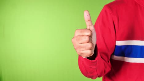 man's hand hand showing a thumb-up on green background