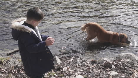 a kid and his dog in the river