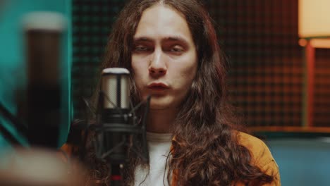 young man speaking in mic during podcast interview in recording studio