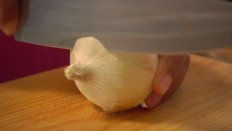 peeling a white onion on a cutting board