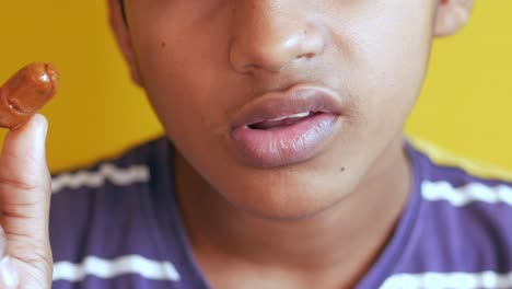 boy putting a candy in his mouth ,