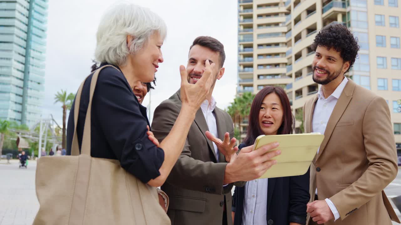 Diverse business team collaborating on a tablet outdoors